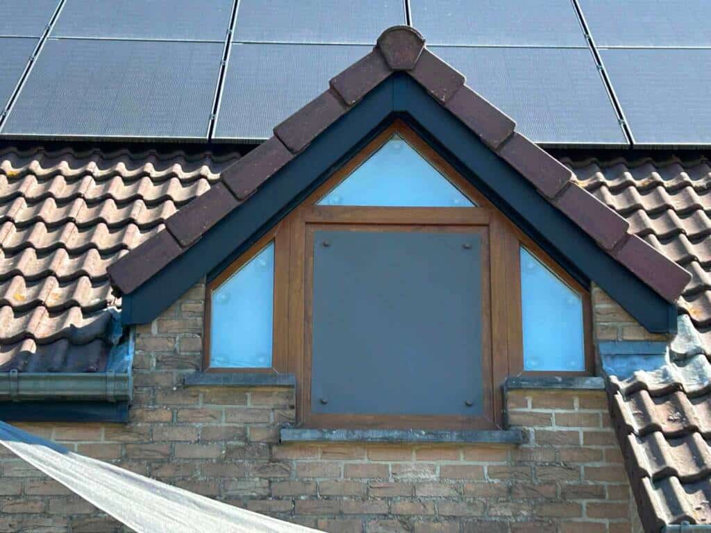 Screen solaire amovible GEKKO taupe profond installé sur une fenêtre rectangulaire, Screen solaire amovible GEKKO glacier installé en intérieur sur une fenêtre triangulaire et trapézoidale.